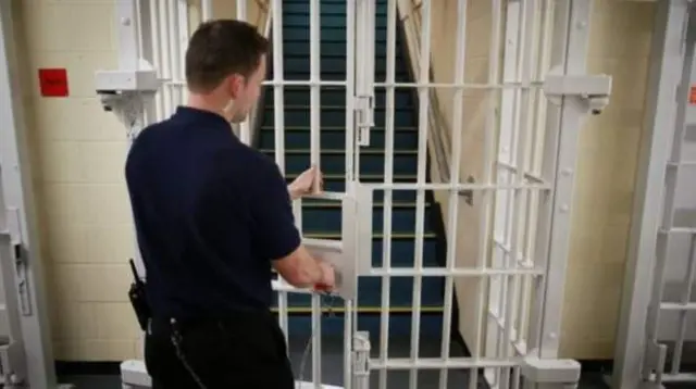 Prison worker locking a door.