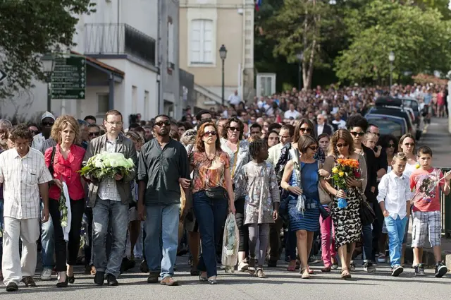 People take part in a silent march on August 3, 2014 in Rouans near Nantes, western France in memory of the seven members of the Ouedraogo family who were aboard the Air Algerie plane that crashed over Mali on July 24