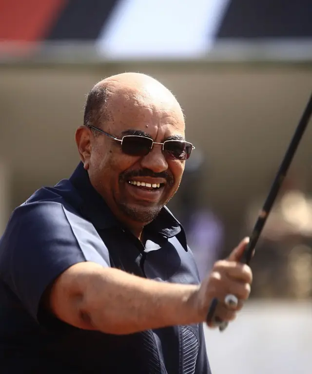 Sudanese President Omar al-Bashir (C) celebrates on stage with a gathering of supporters in the Green Square in the capital Khartoum on October 11, 2016 following the declaration of an extension of a cease-fire