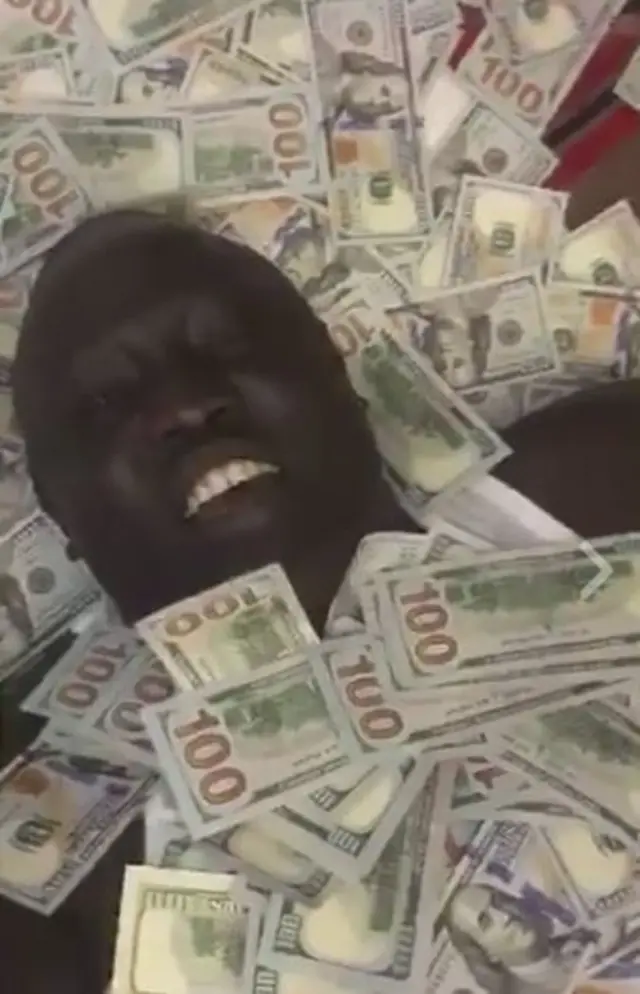 Lawrence Lual Malong Yor Jnr with his body covered in notes