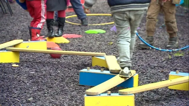 A low-angle shot showing children's legs in a playground