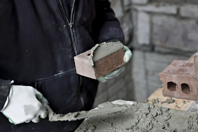 builder laying bricks