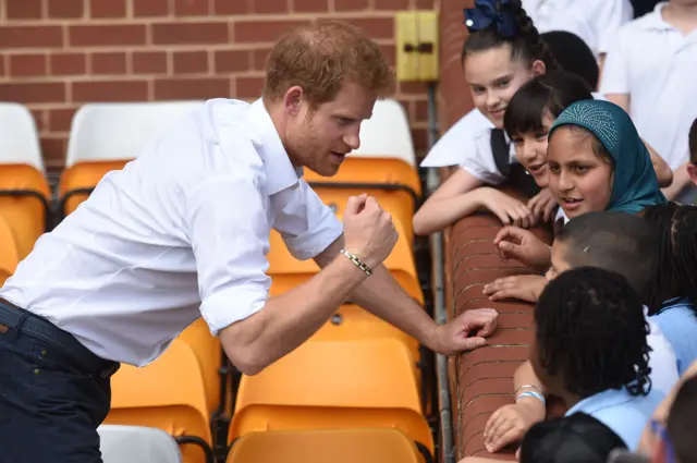 Prince Harry speaking to children