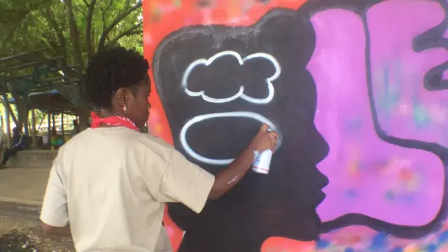 Tanzanian woman spraying grafitti