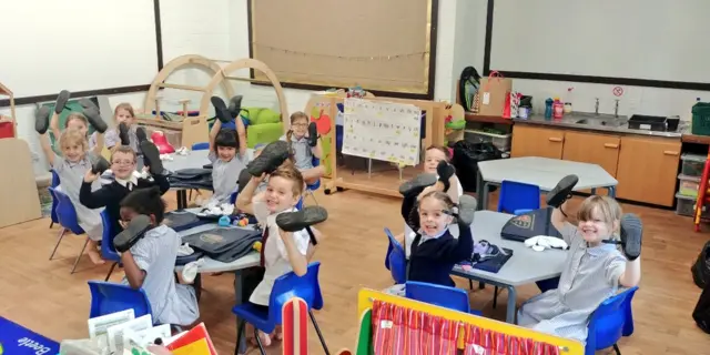 Kids holding they're shoes in the air