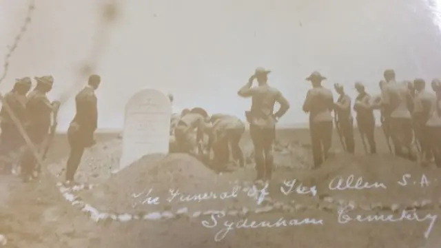 The coffin of a British solder is lowered into the ground at a funeral during the war