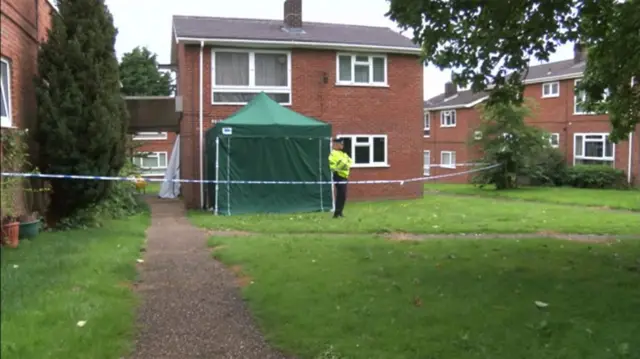 Godric Place, with police officer and police tent outside ground floor flat