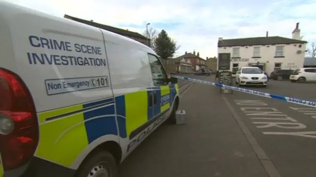 Police vehicle in front of a pub