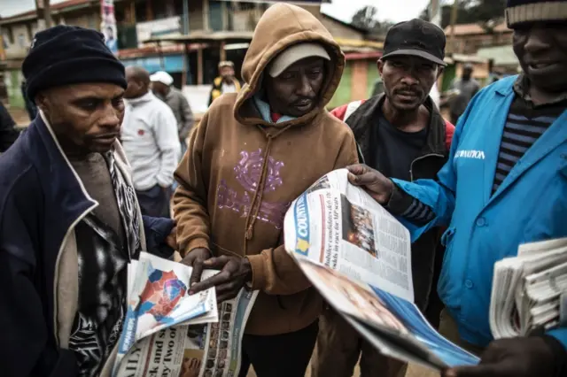 People looking at newspapers