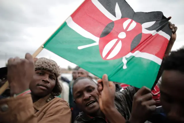 Kenyans hold the national flag