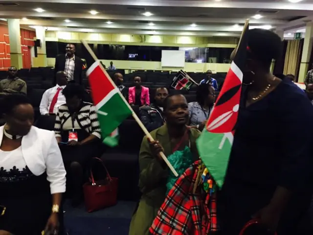 Woman holding Kenyan flags