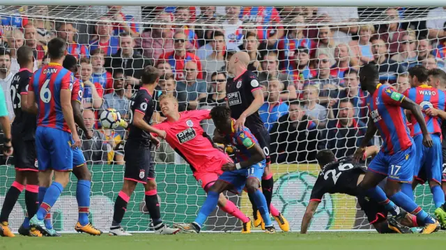 Jonas Lossl saves Christian Benteke's header at the goal