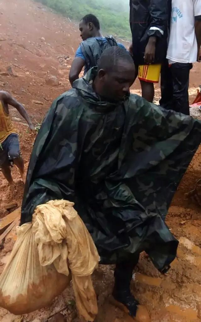 Man holding a bag in the mud