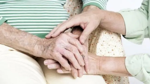 Older person being comforted by family member