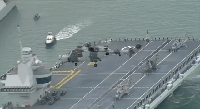 Helicopter over aircraft carrier