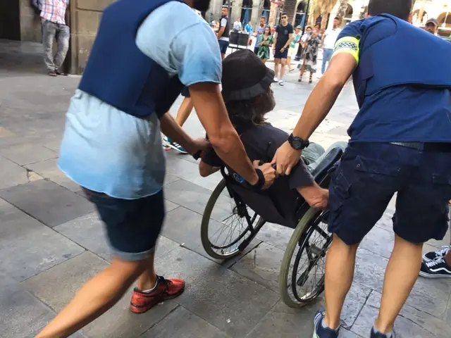 Police help a man in a wheelchair evacuate the area