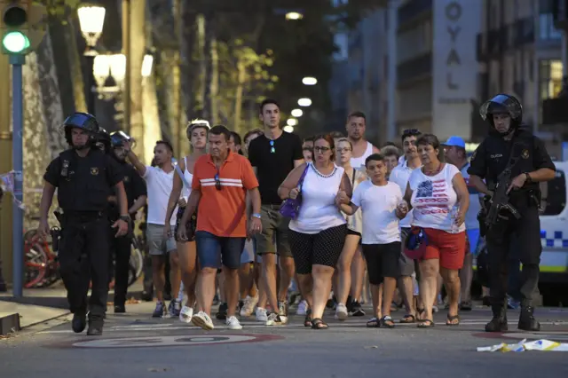 Police escort people close to the scene