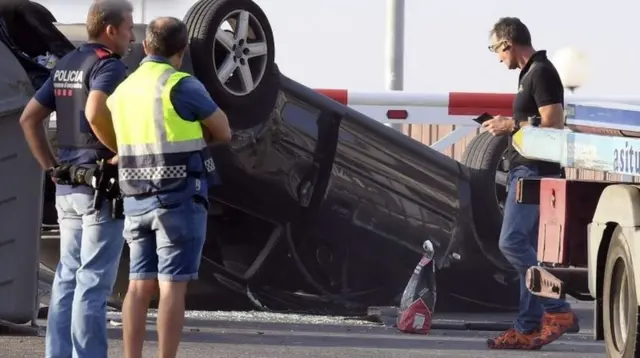 Policemen check the car involved in the attack in Cambrils