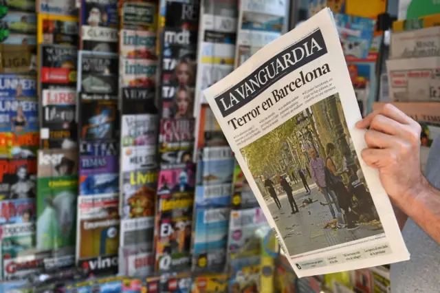 A person reads the Catalan newspaper La Vanguardia on August 18, 2017