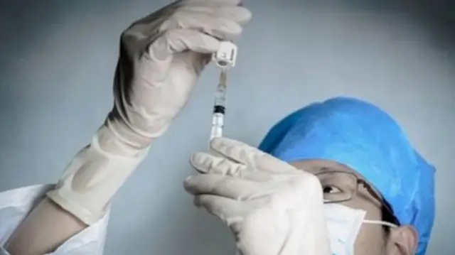 Doctor filling a syringe with a drug.