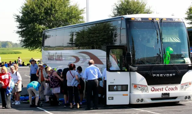 A coach bus unloads a group of British tourists in Kentucky