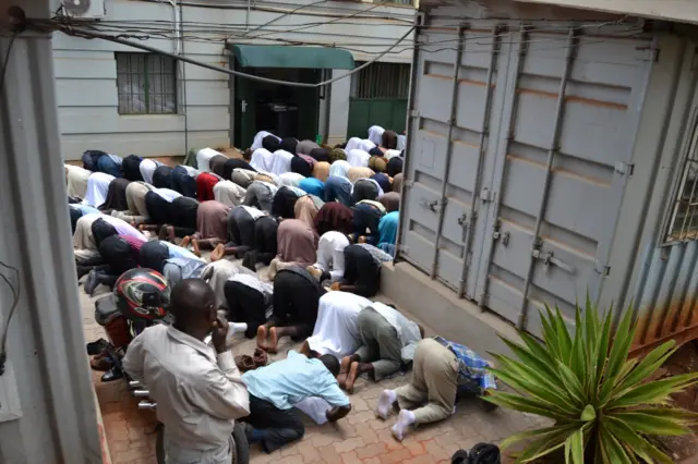 Supporters of the accused pray for them outside court on Monday