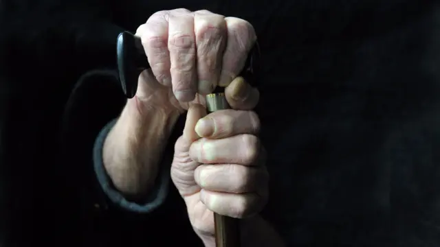 Hands holding a cane