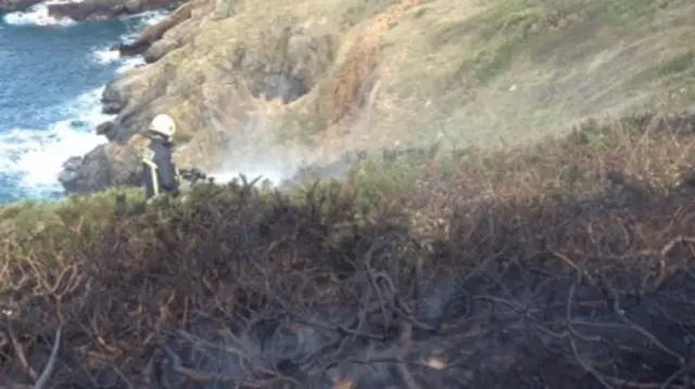 Sark fireman extinguishing the cliff blaze