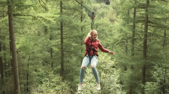 Girl on zipwire in tree tops