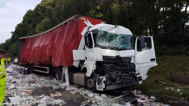 Lorry surrounded by spilllage of bottles