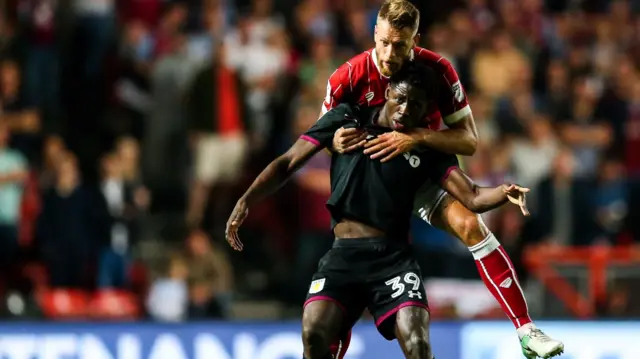 Keinan Davis of Aston Villa is challenged by Nathan Baker of Bristol City