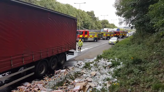 Lorry surrounded by spilllage of bottles