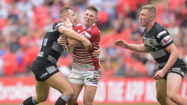 George Williams of Wigan Warriors is tackled by Liam Watts of Hull FC