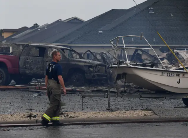 A firefighter walks near a burnt-out house in Corpus Christi, Texas