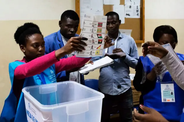 A polling station official handles ballot papers in the capital, Luanda, on election day