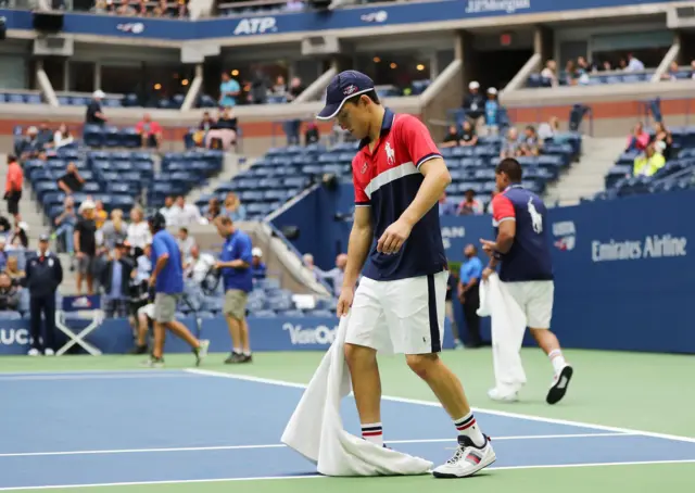 The grounds crew attends to the court