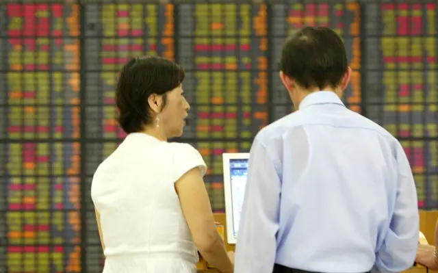 People in front of stock market board