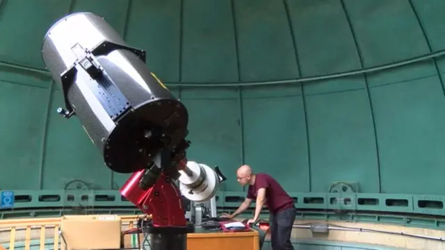 Ryan MacDonald looking through a telescope.