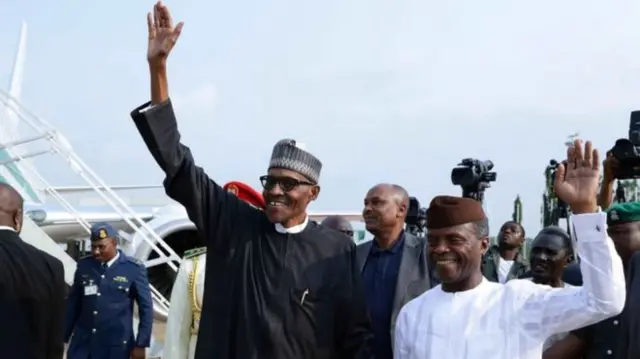 Muhammadu Buhari greets supporters as he steps off the presidential jet