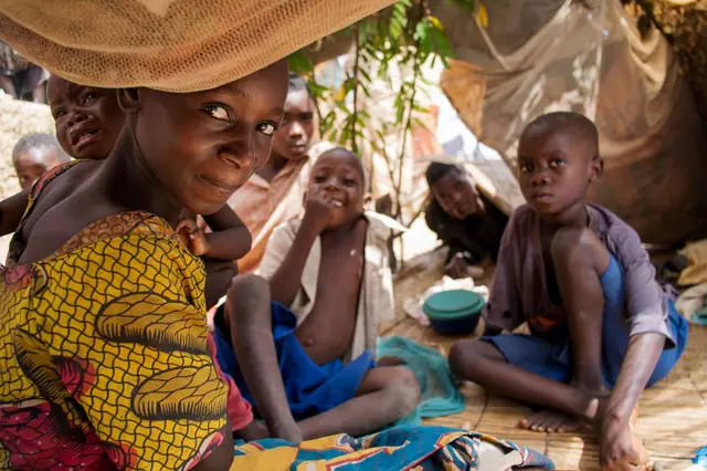 Burundian refugees gather along the shoreline of the Tanganyika lake in the fishing village of Kagunga, on May 21, 2015. UNHCR is transporting approximately 2000 refugees per day to a transit camp at the stadium in Kigoma.