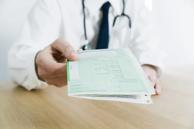 Doctor handing over prescription notes