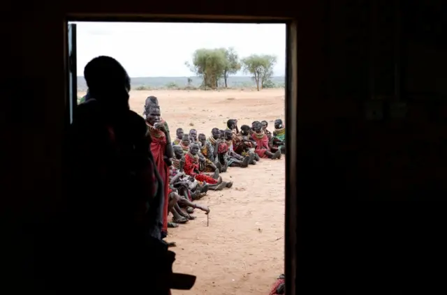 Members of Turkana tribe wait to vote in front of a polling station during elections in a village near Barago