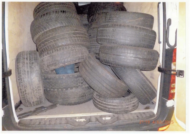 A person hidden amongst tyres