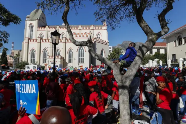 Supporters of opposition parties watch and listen to a broadcast of parliamentary proceedings during a motion of no confidence in the president in the street outside parliament in Cape Town, South Africa 08 August 2017.
