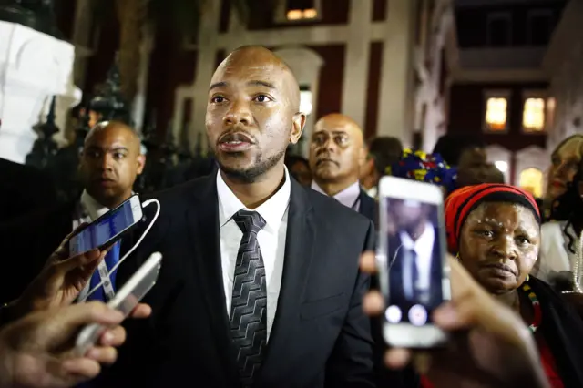 South Africa's main opposition party Democratic Alliance (DA) leader Mmusi Maimane (C) reacts after leaving following the South African president speech for the 2017's State Of the Nation Address (SONA) at the Parliament in Cape Town on February 9, 2017.