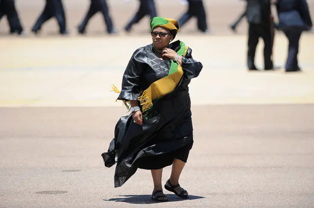 South African Defence Minister Nosiviwe Mapisa-Nqakula accompanies the coffin former president Nelson Mandela on December 14, 2013 at the Waterkloof air force base in Pretoria before the departure of Mandela's coffin to Mthatha and Qunu where he will be buried tomorrow