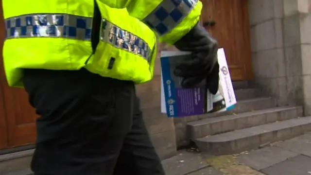 Police officer handing out Operation Sanctuary leaflets