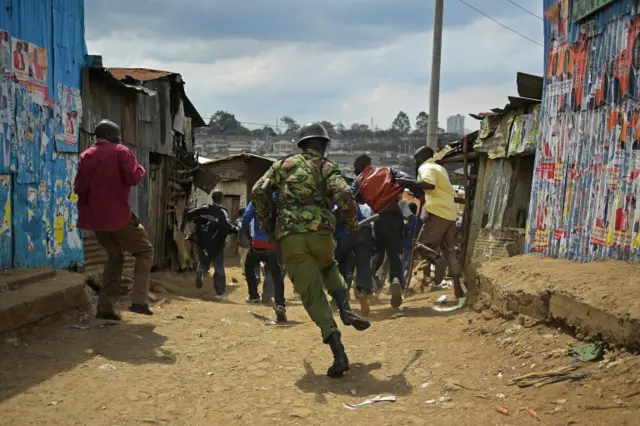 Kenyan police chase protestors in Mathare slum in Nairobi on August 9, 2017, a day after general elections.