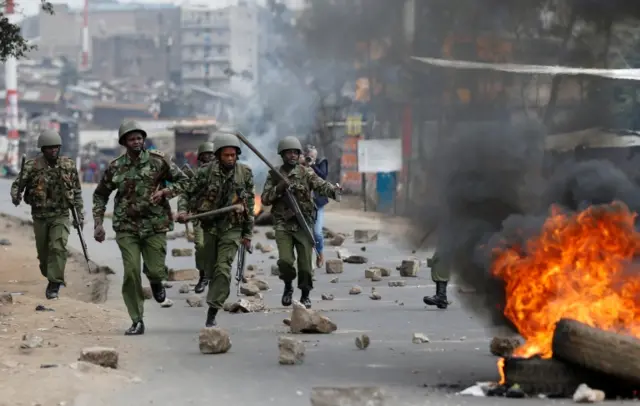 Anti riot policemen deploy after protesters set tyres on fire in Mathare, Nairobi, Kenya August 9, 201