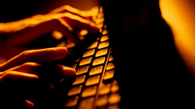 Hands typing on a computer